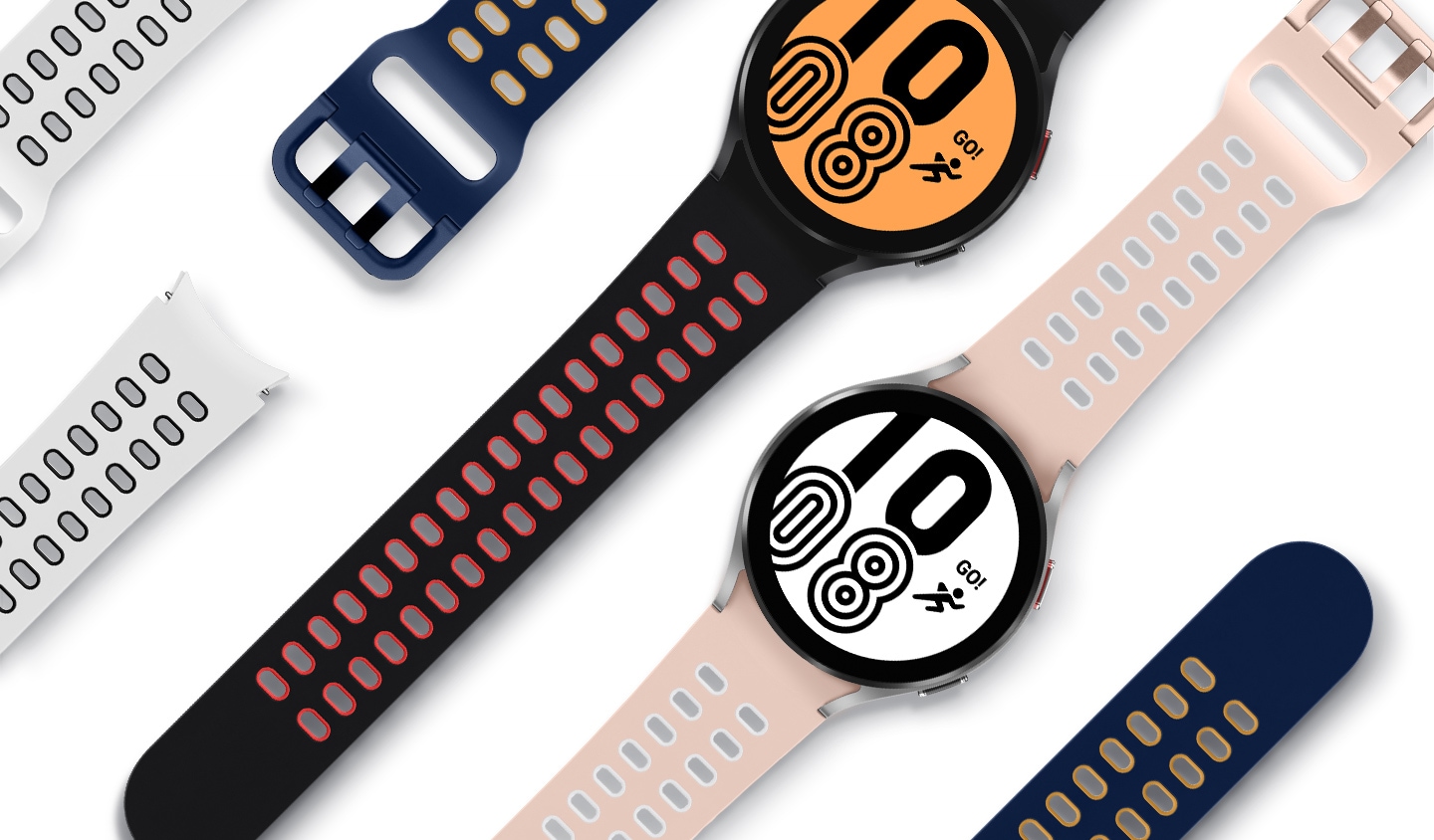 Two Galaxy Watch4 devices are laid straight, each attached with an Extreme Sport Band. Several other Extreme Sport Bands are shown beside the watch devices. The bands are in different colors, including white, black, navy, and pink.