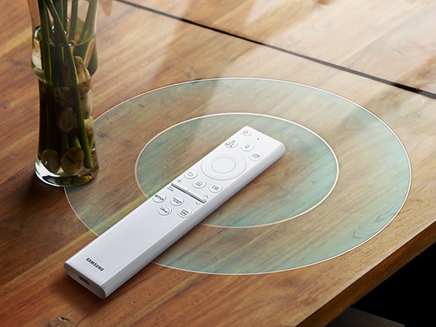 A SolarCell Remote is on a table next to a vase emitting signals in circular motion.