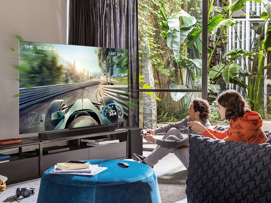 Two friends are enjoying an immersive gaming experience with Samsung Soundbar Game Mode Pro.