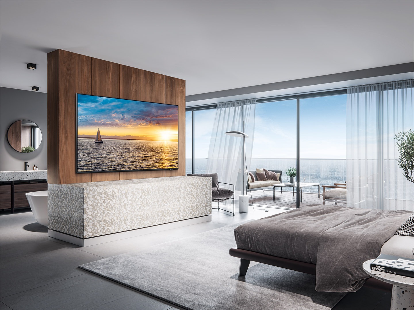 A wall-mounted QLED TV is installed in a luxurious hotel room with a sea view out the window.