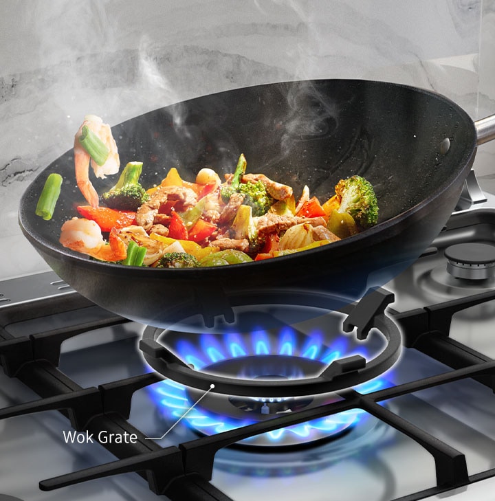 Stir-fried food is being prepared in a wok above the circular Wok Grate.