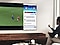 A man is watching a soccer game on his TV simultaneously reading the news on the same screen.