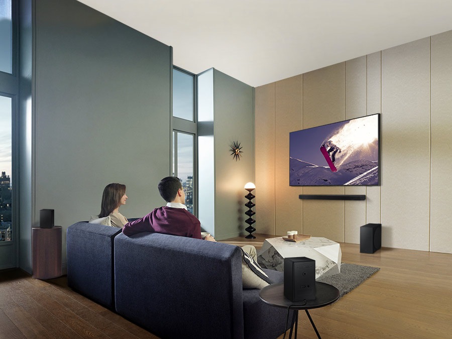 Family watches animation in immersive surround sound with Samsung Wireless Rear Speaker Kit and Soundbar activated together.