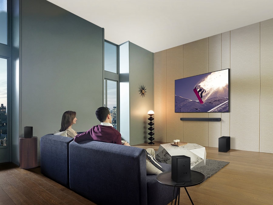 Family watches animation in immersive surround sound with Samsung Wireless Rear Speaker Kit and Soundbar activated together.