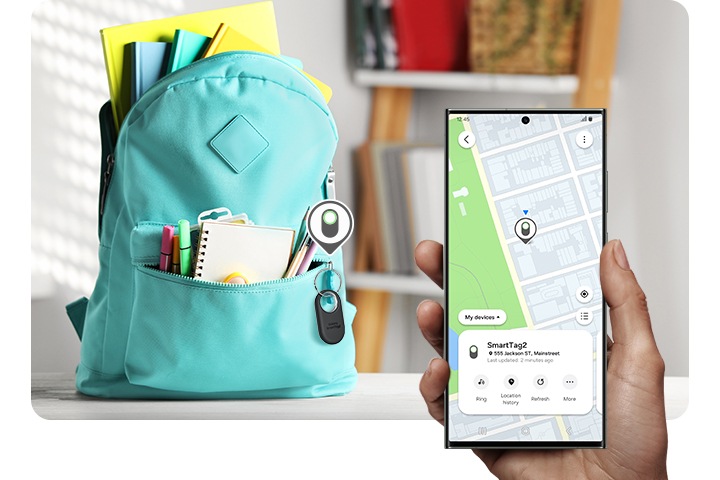 In the background, a child's backpack in a child's room is placed on a table with a Galaxy SmartTag2 device tagged as a keychain. Hovering above the device is the SmartTag2 icon. In the foreground, a hand holding a Galaxy smartphone device shows the map location of the Galaxy SmartTag2 device on SmartThings Find.