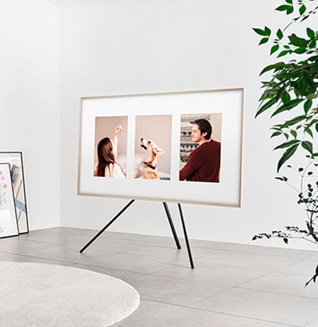 The Frame TV is set horizontally on the Studio Stand. It displays three photographs against a white matte background.