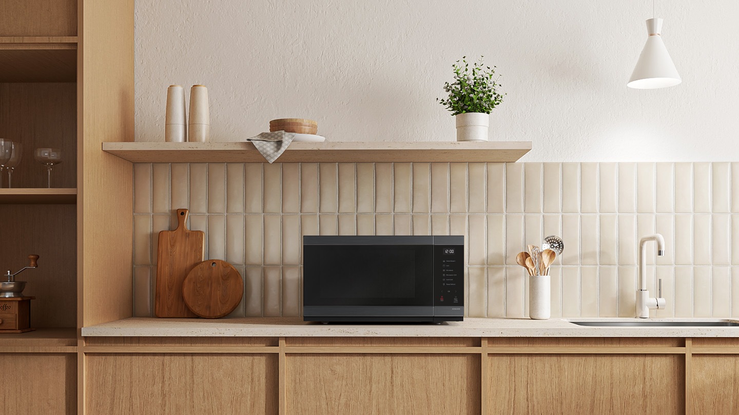 Shows the microwave oven on the counter top of a modern kitchen.