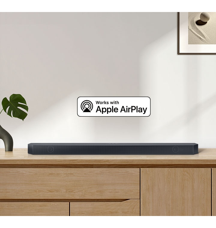 A Samsung Soundbar sits on top of a cabinet, accompanied by a logo for Works with Apple AirPlay.