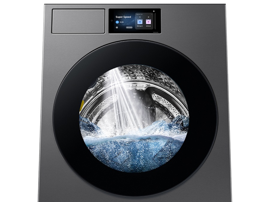 A powerful jet of water is spraying into the washing machine drum.