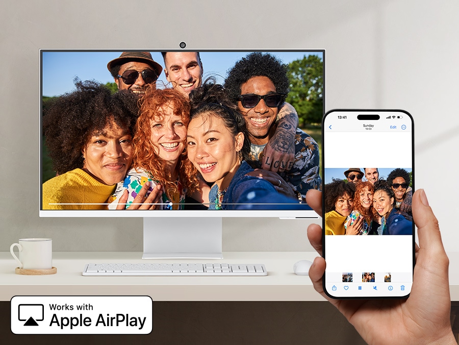 A smartphone wirelessly mirrors a group photo to a large monitor using Apple AirPlay. Works with Apple AirPlay logo.
