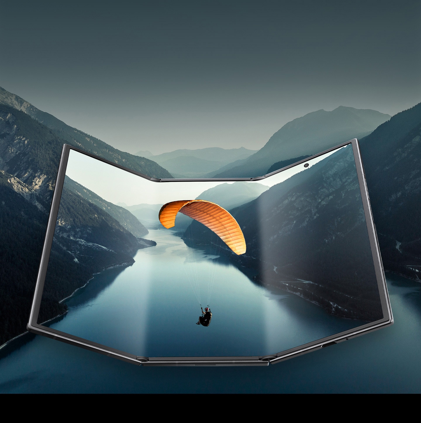 Galaxy Z TriFold seen mostly unfolded to show the expansive main screen. A view of a landscape is seen on the screen and the image continues past the boundaries of the device to demonstrate the cinematic view.