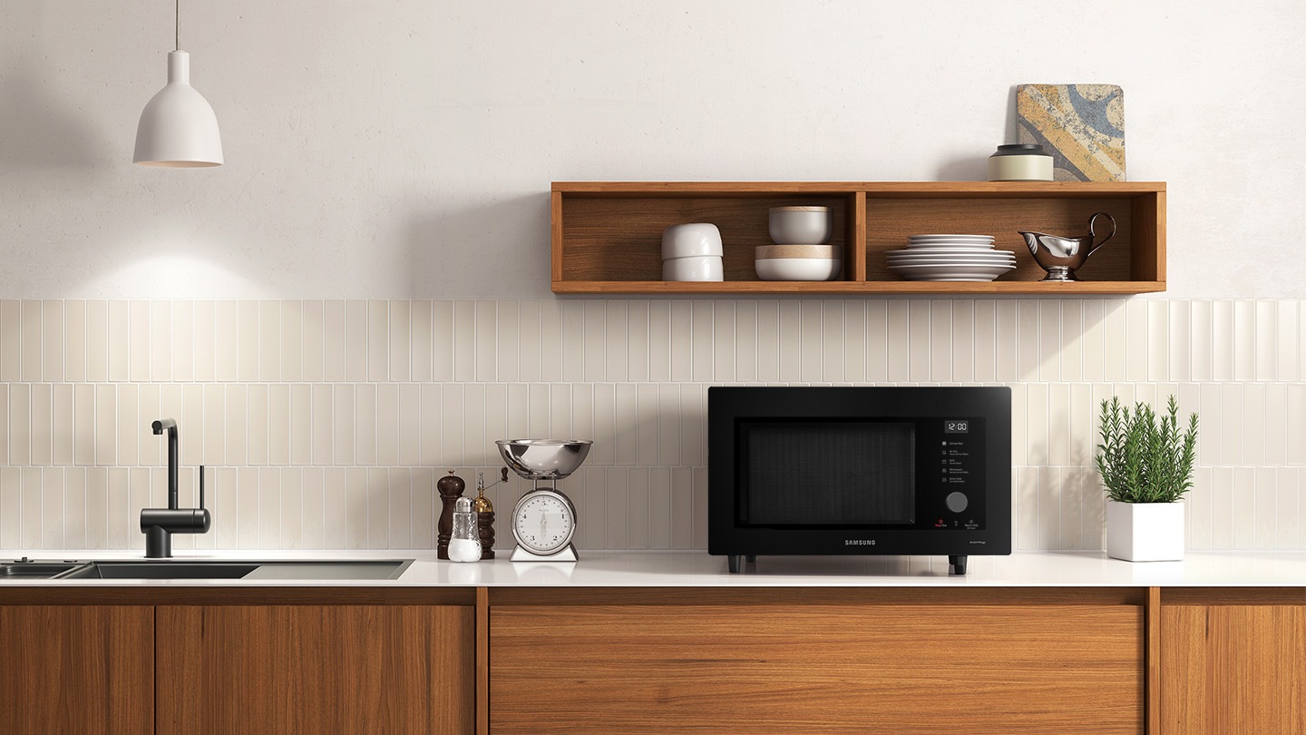 Shows the microwave oven on the counter top of a modern kitchen.