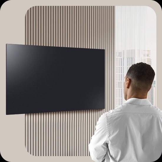A man looks at a blank TV screen. The screen activates to display Daily Board, which shuffles through widgets for Weather, Memo, Music, Home Stats, Samsung TV Plus and Tips. It also displays the time and date, along with a voice prompt to play relaxing music.