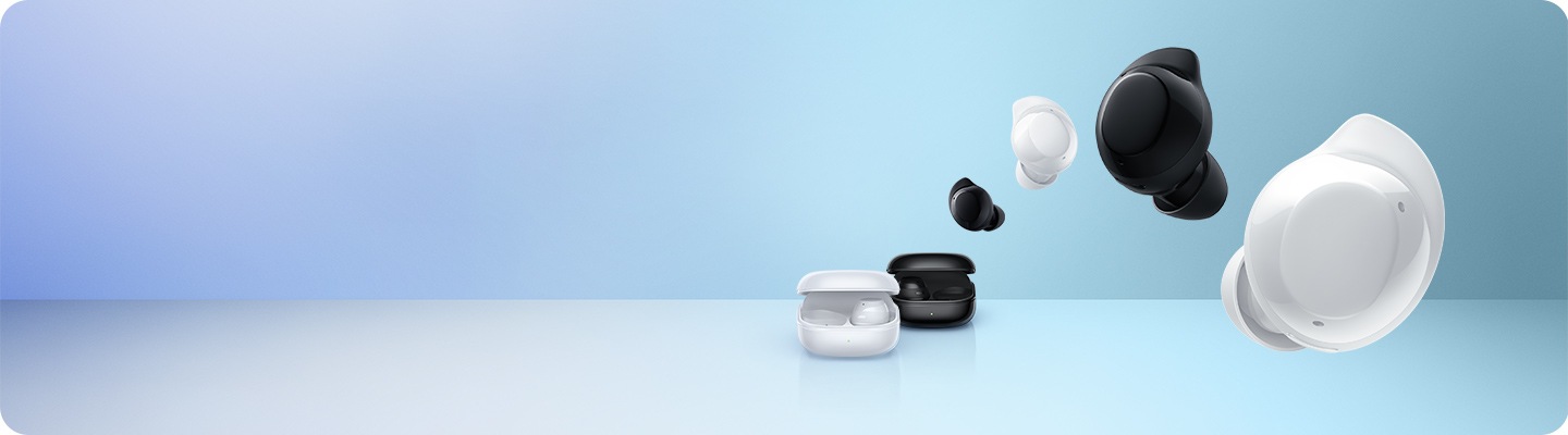 The white Galaxy Buds Core charging case is in front of the black Galaxy Buds Core charging case. Overhead are four Galaxy Buds Core earbuds arranged in alternating black and white colors in the following order black, white, black, white.
