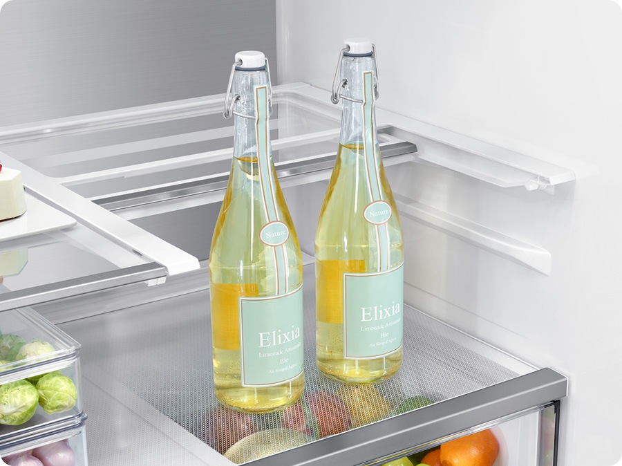 There is a closeup of a folded slide-in shelf inside the refrigerator. There are two tall glass bottles.