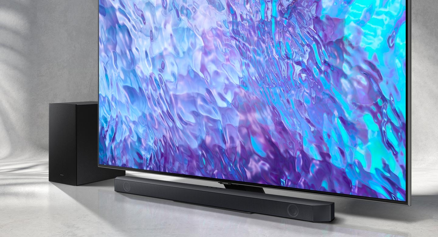 A barra de som e o subwoofer da série Q da Samsung são posicionados com a TV QLED.