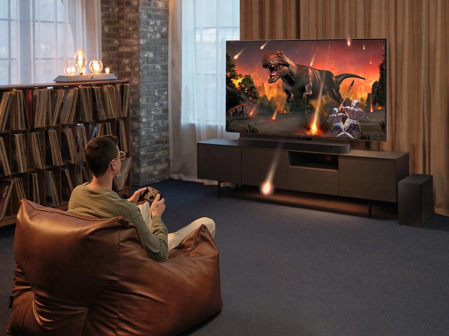 Um homem desfruta de uma experiência de jogo imersiva semelhante a 3D com o Samsung Soundbar Game Mode Pro.