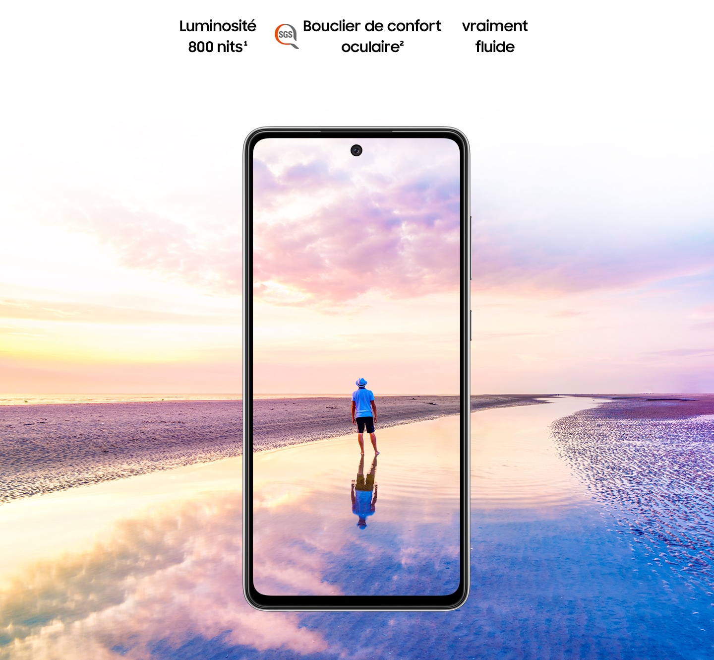 Galaxy A52 vu de face. La scène d’un homme debout sur une plage au coucher du soleil avec des couleurs roses et bleues dans le ciel s’étend hors des limites de l’écran. Le texte indique Luminosité 800 nits, Eye Comfort Shield, avec le logo SGS et Real Smooth.