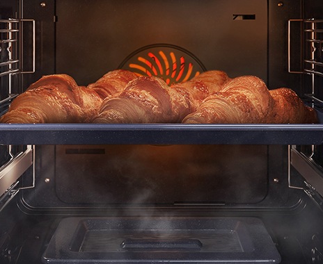 Shows a close-up of croissants being baked in the oven, but being kept moist with steam using the Natural Steam option.