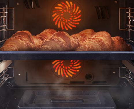 Shows a close-up of croissants being baked in the oven, but being kept moist with steam using the Natural Steam option.