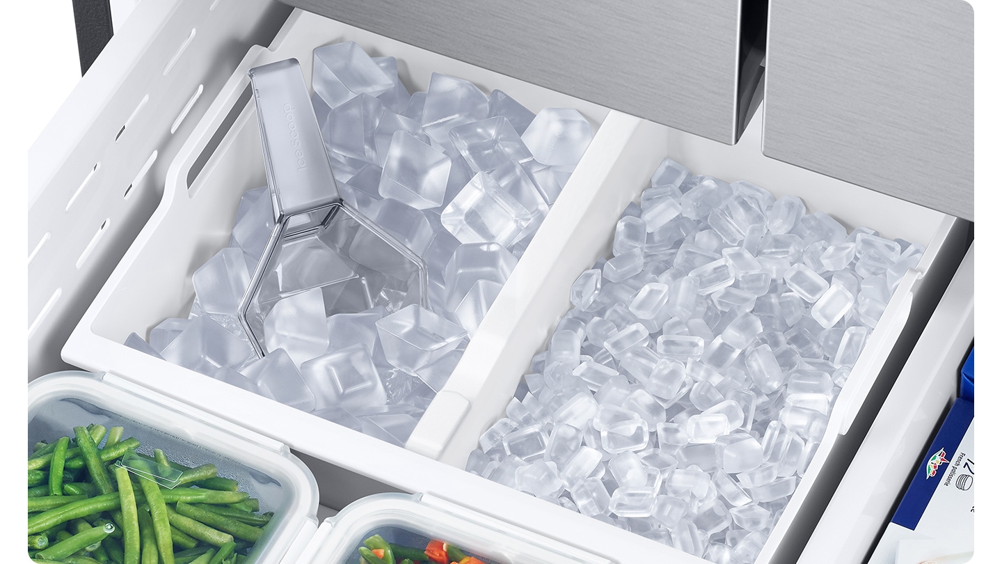 The dual tray in the freezer is full of ice. The left tray is full of large ice cubes and the right tray is full of small ice cubes.