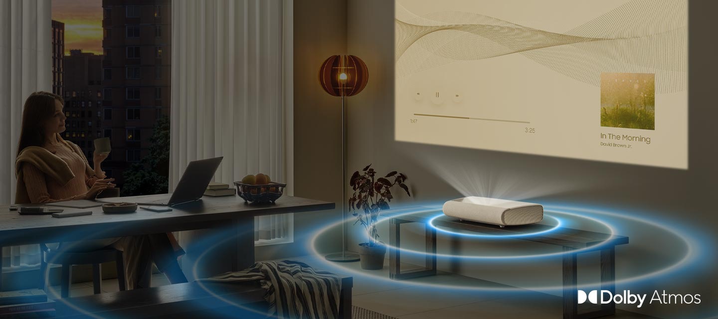 O femeie transmite muzică către The Premiere, care emite inele de sunet Dolby Atmos în toată camera.