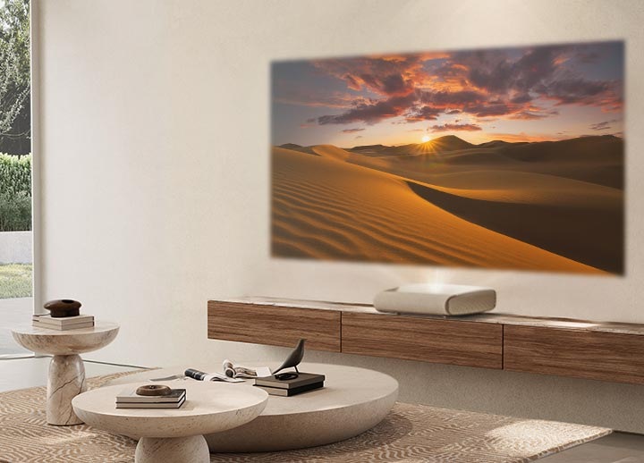 Într-un living însorit, The Premiere proiectează pe perete un peisaj deșertic luminos, care poate fi văzut clar.