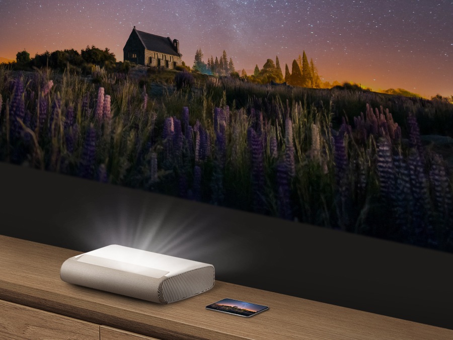 Un dispozitiv mobil este așezat lângă premieră. Aceeași imagine de pe dispozitiv este proiectată pe perete de către Premieră.