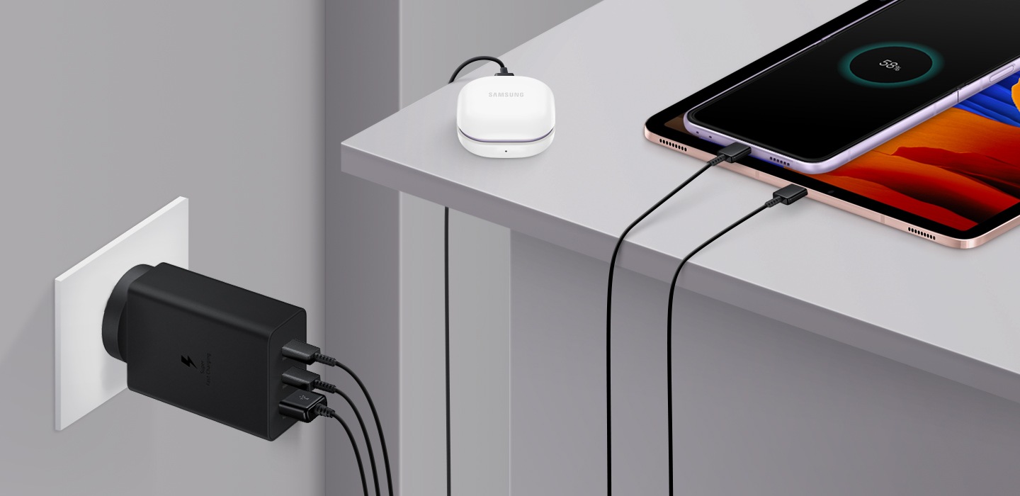 65W Power Adapter Trio is plugged into the wall outlet to charge smartphone, tablet PC and Galaxy Buds2 at the same time.