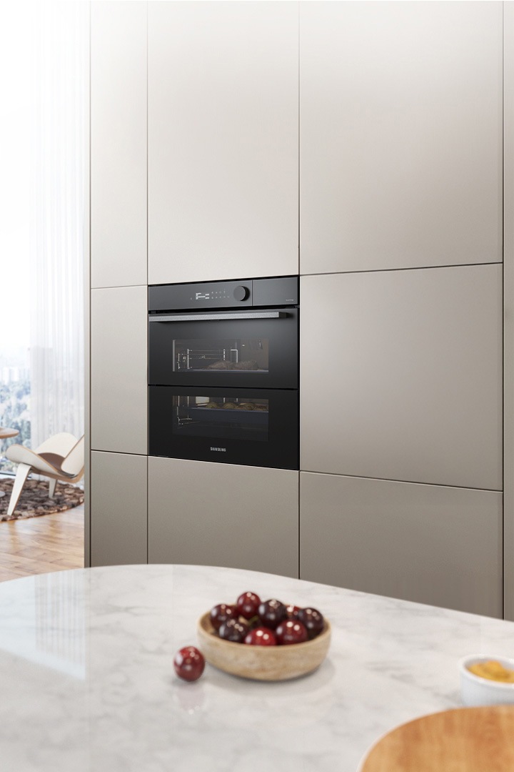 Shows the built-in oven installed in a kitchen, with two cooking zones and a hinged door, next to a Microwave Combi oven.