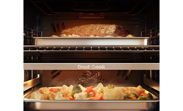 Shows the inside of the oven with a joint of meat roasting in the upper zone and vegetables in a covered dish being steamed in the lower zone.