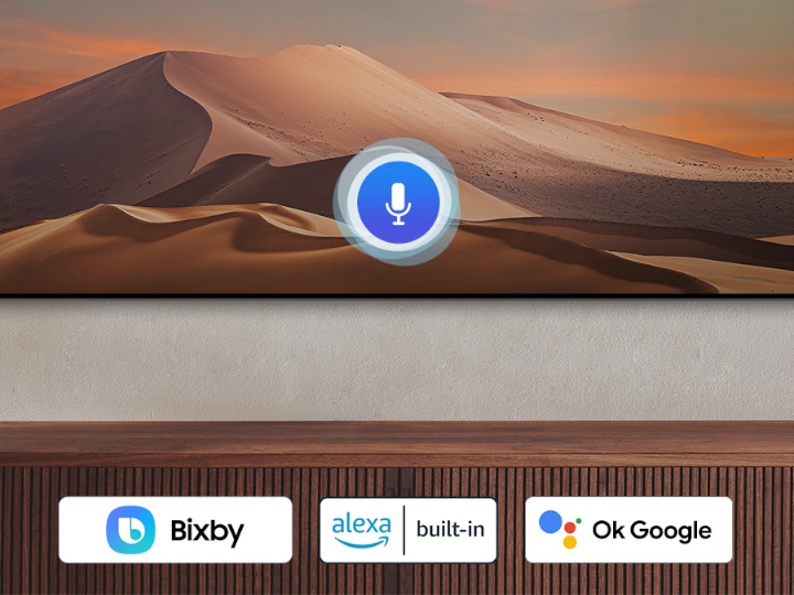 A microphone icon overlays an image, demonstrating voice assistant feature. The Bixby, Alexa built-in and the OK Google logos are on display on the bottom.