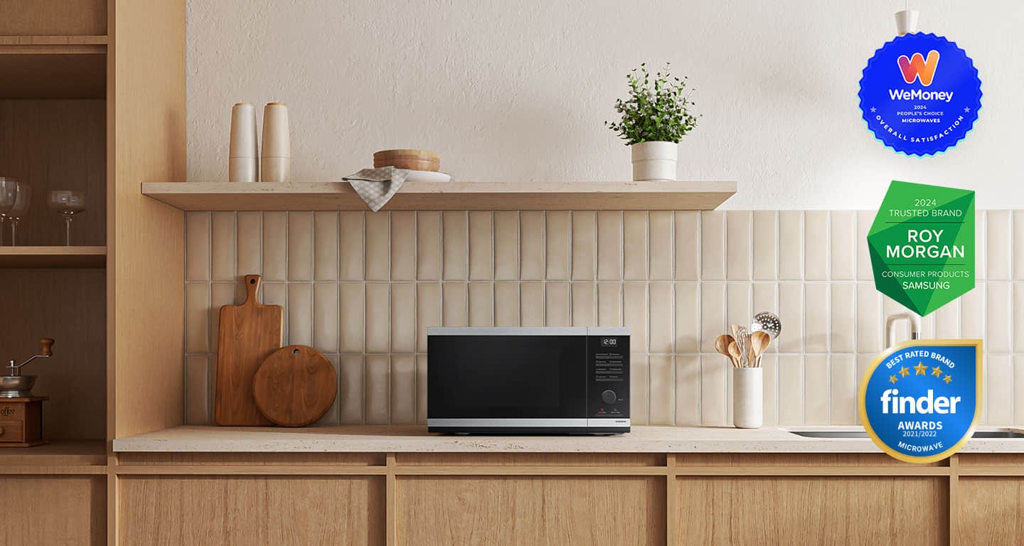 Shows the microwave oven on the counter top of a modern kitchen.