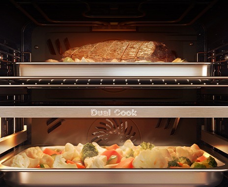 Shows the inside of the oven with a joint of meat roasting in the top zone and vegetables being steamed in the lower zone.