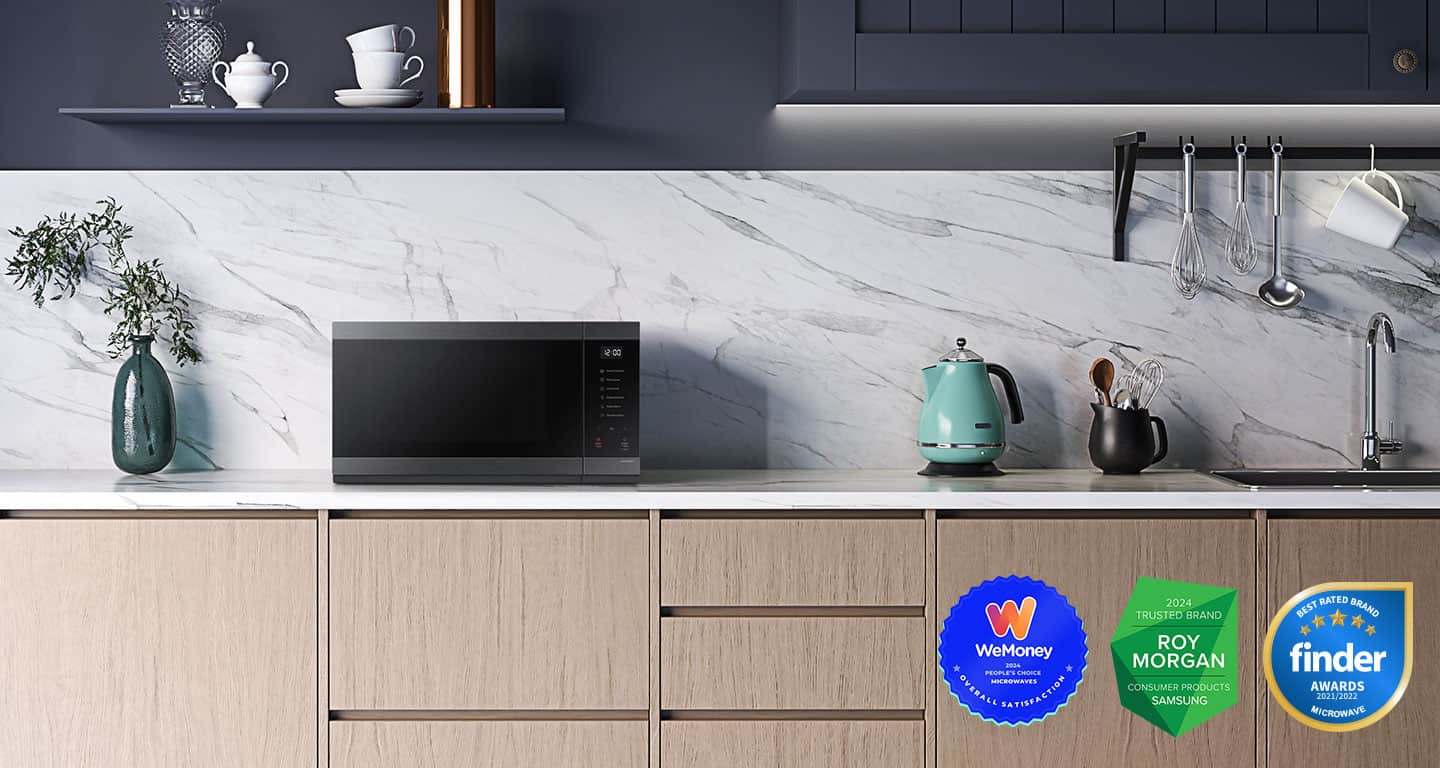 Shows the microwave oven on the counter top of a modern kitchen.