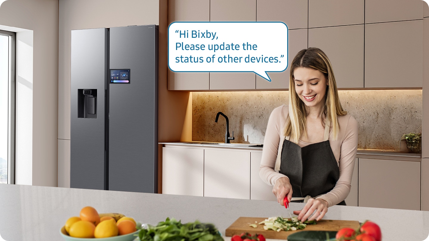 Shows a person preparing food while controlling the refrigerator using a Samsung Bixby. “Hi Bixby, Please update the status of other devices.”