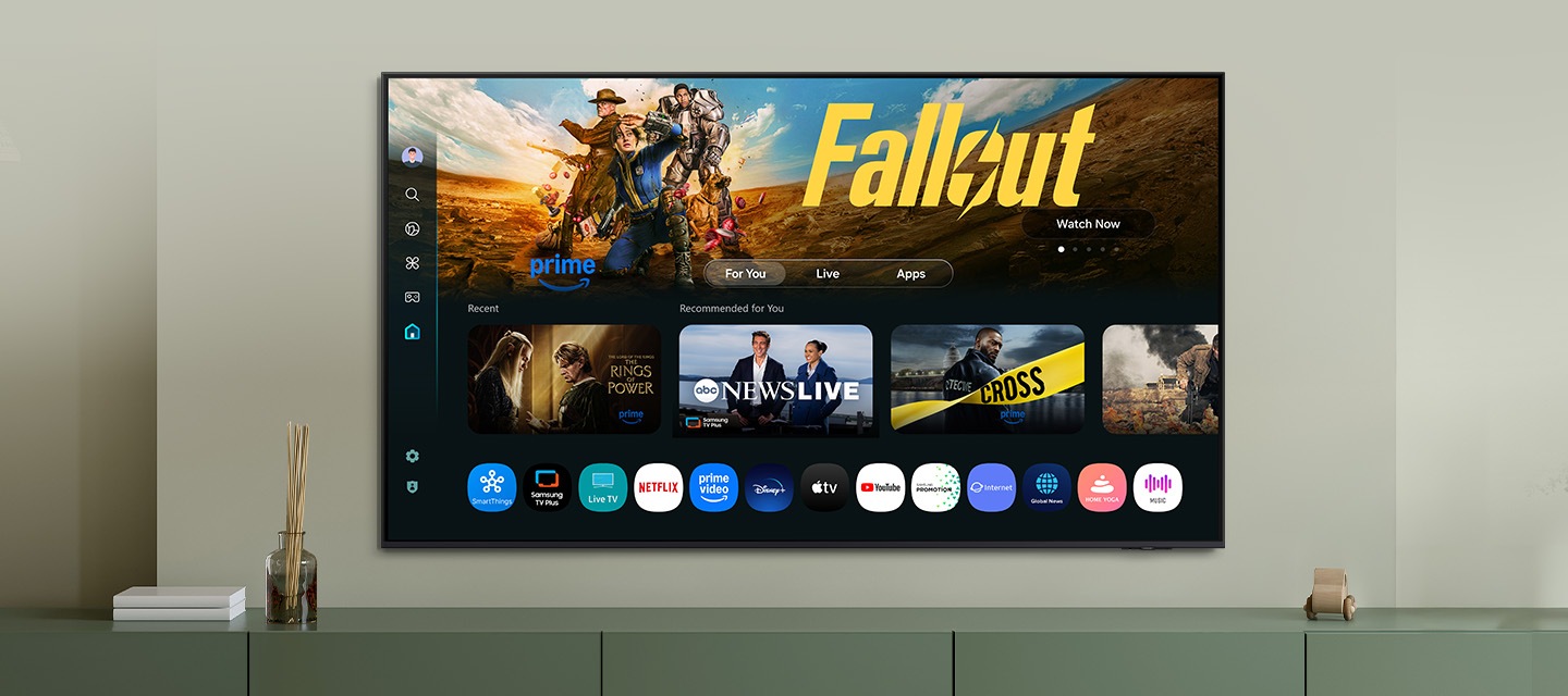 One UI Tizen’s home screen, with the various apps and services available, is displayed on a TV in a living room.