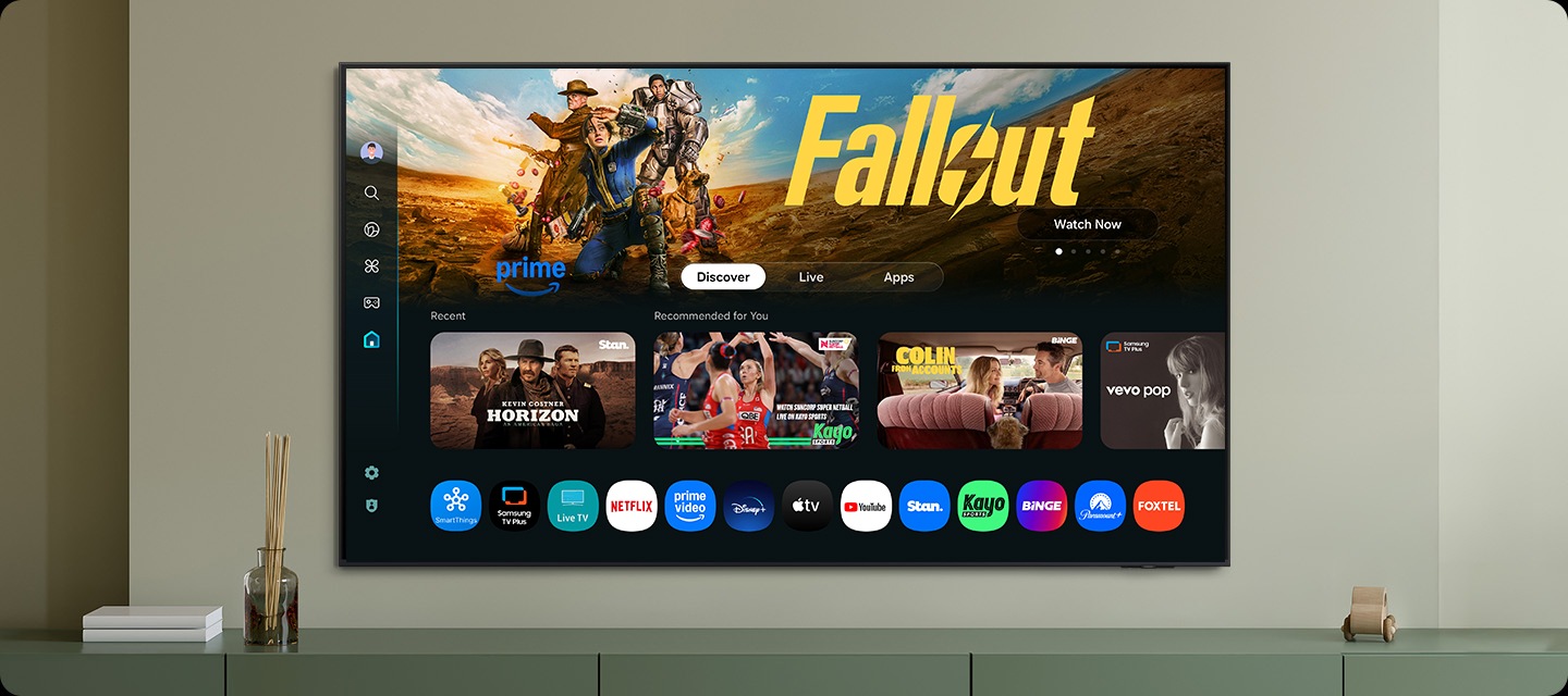 One UI Tizen’s home screen, with the various apps and services available, is displayed on a TV in a living room.