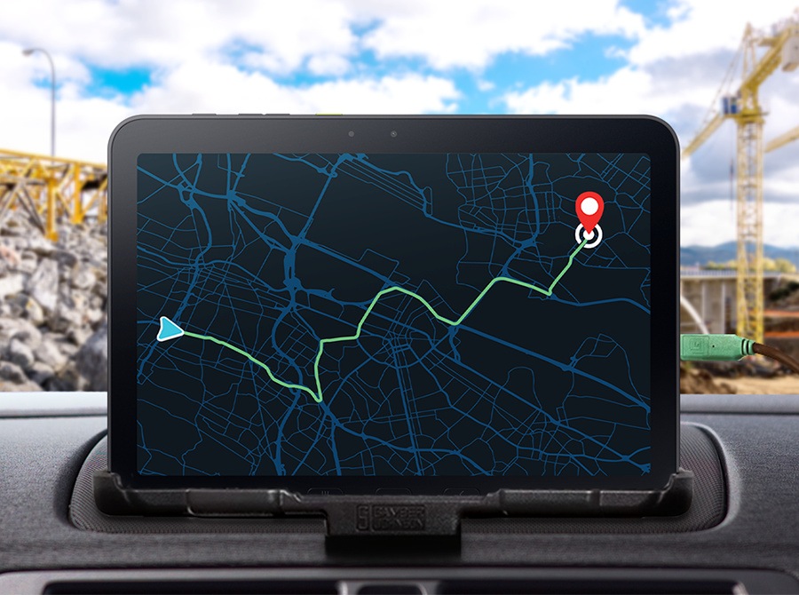 Galaxy Tab Active5 Pro is positioned inside a vehicle, displaying a map with route guidance to a destination. A construction site is visible outside, illustrating how the device can operate directly from external power without using a battery.