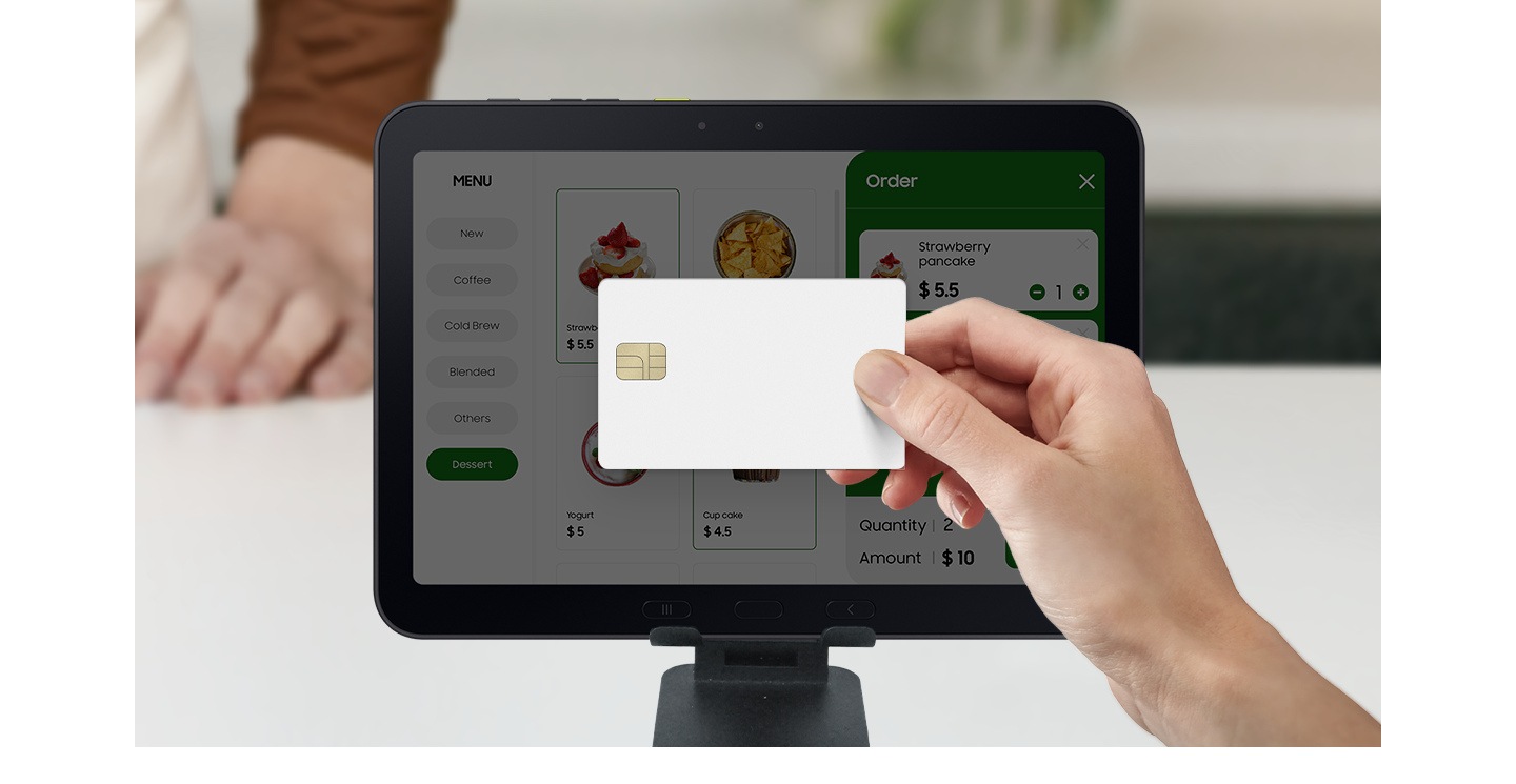 A hand holds a credit card near the Galaxy Tab Active5 Pro screen to make a payment at a restaurant. Galaxy Tab Active5 Pro is used to display the menu, take orders and process payments.