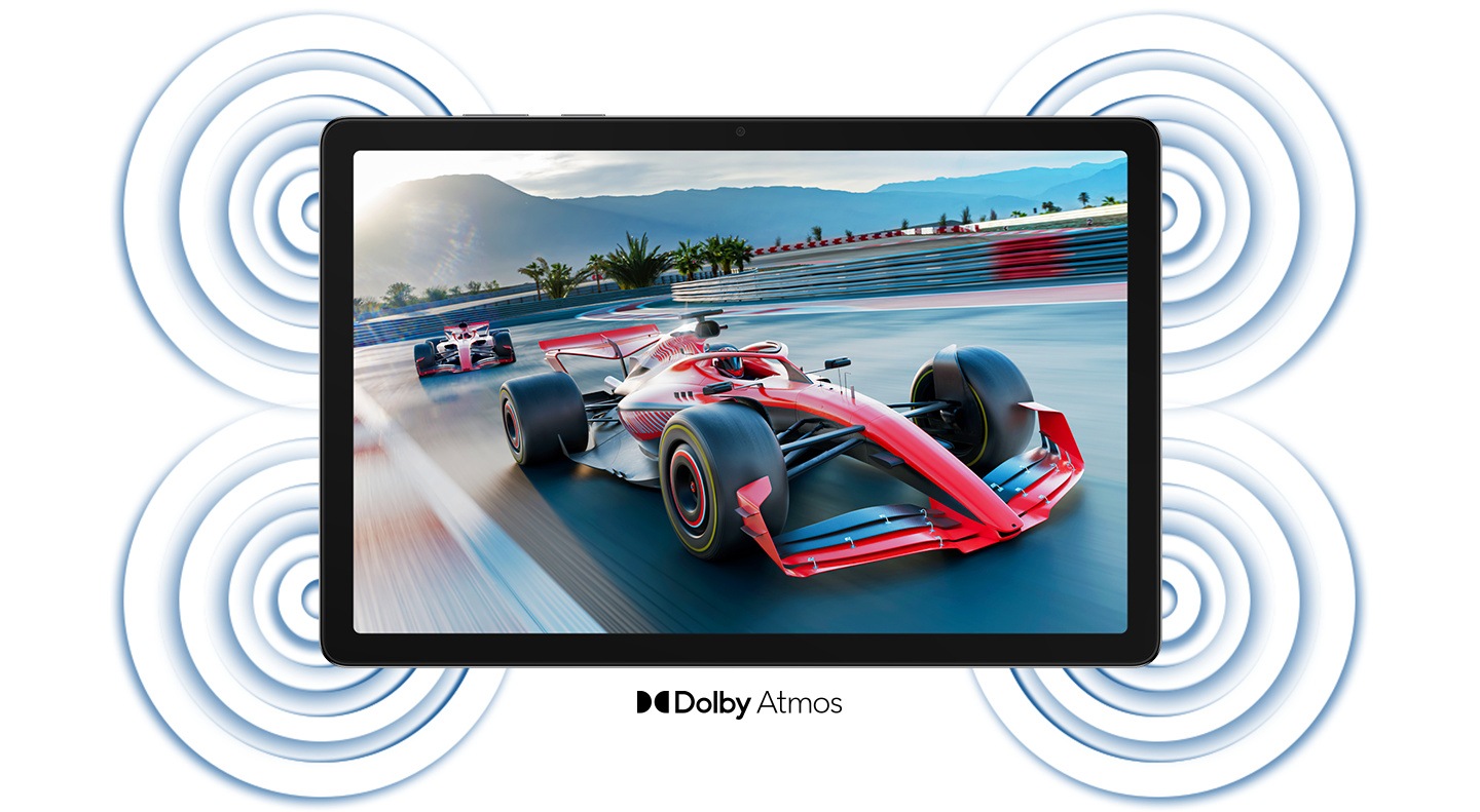 A horizontally placed Galaxy Tab A11+ is shown from its screen-side. On its screen is a scene from the track of a motorsport race featuring racing cars. Around the device, circular lines are shown near its four corners. The lines represent Dolby Atmos Quad speakers and can be associated with its high-quality surround-sound system. On the bottom reads 'Dolby Atmos' alongside its brand logo icon.