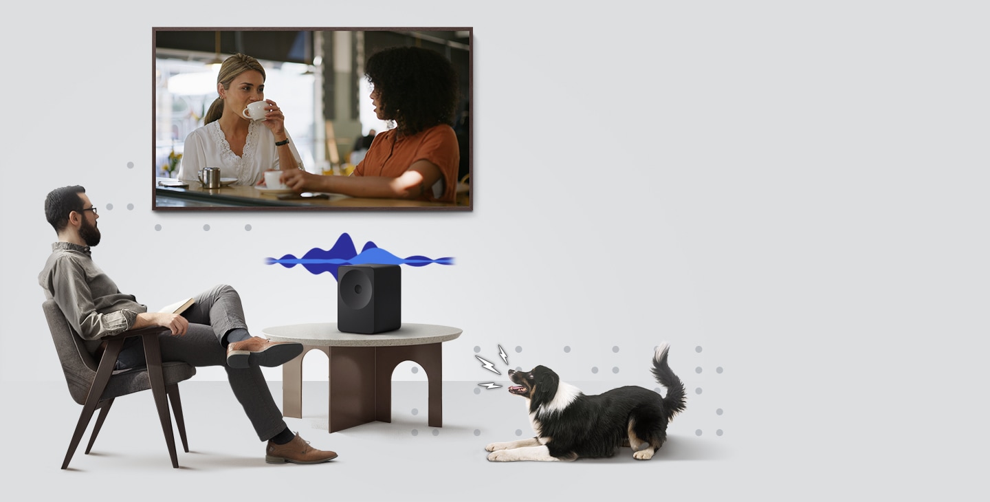 A man watches TV with a scene of two people having a dialogue while a Music Studio 7 speaker sits on a table beneath it. As a dog barks nearby, visual sound waves shift to emphasize voices, illustrating Active Voice Amplifier Pro detecting background noise and boosting on-screen dialogue for clearer, easier-to-follow speech.
