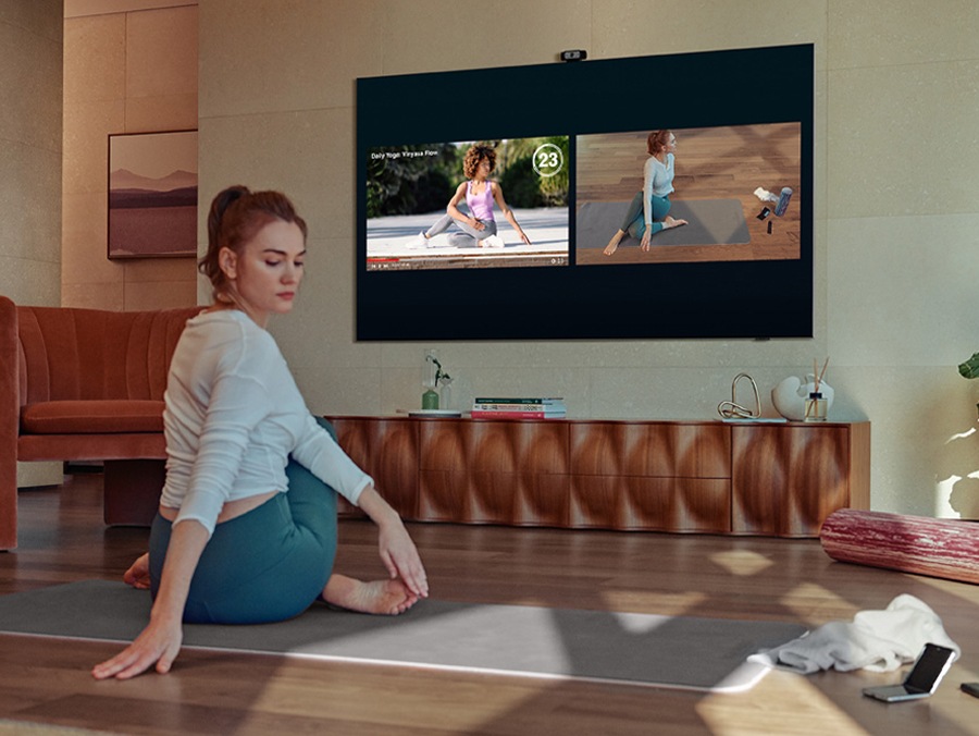 A girl doing exercise while watching instructions on TV