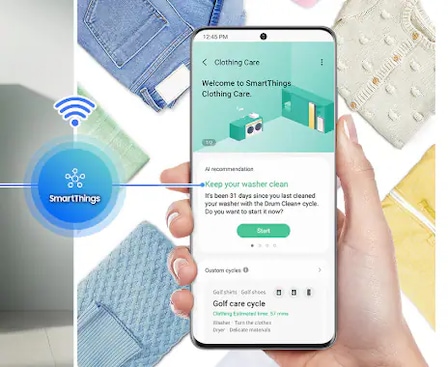 Image highlight shows SmartThings app connectivity through a model phone to monitor and control the washing settings.