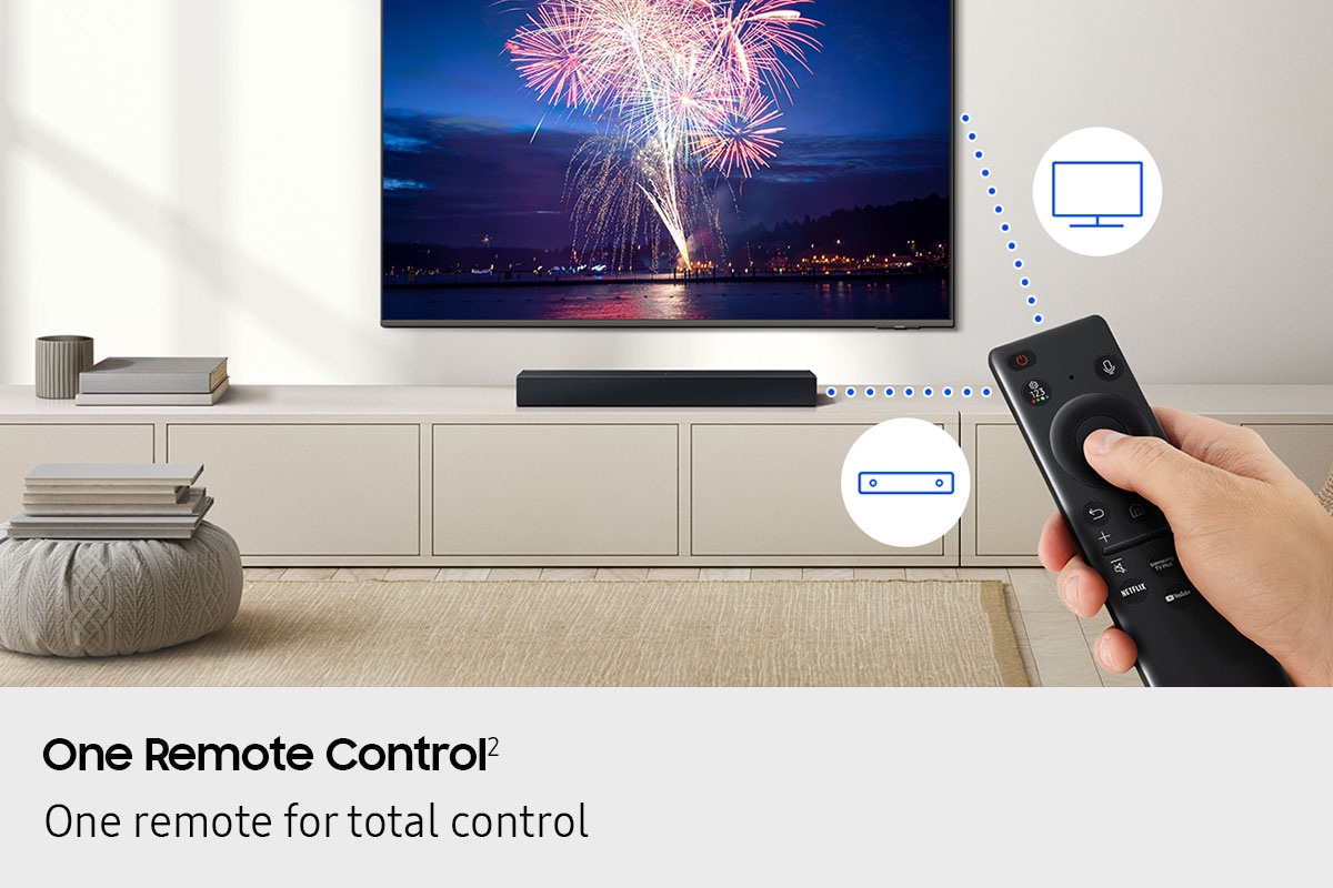 In a living room, a remote control is used to control both a TV and soundbar, shown by dotted lines and icons of the devices.