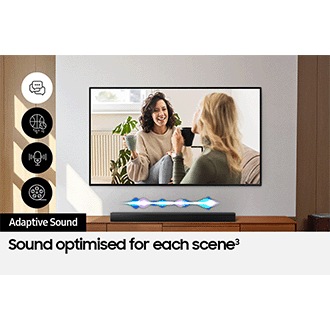A TV shows a scene of two women talking. Adaptive Sound optimizes the Soundbar's audio, shown by a fluctuating sound wave.