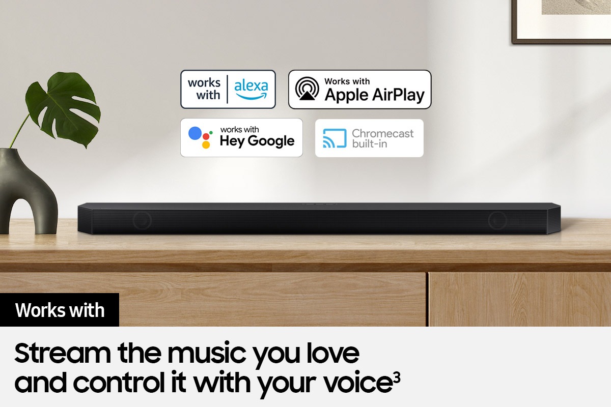 Alexa logo, Apple AirPlay logo, Hey Google logo, and Chromecast Built-in logo can be seen along with Samsung Q700B soundbar which is sitting on living room cabinet.