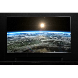 The QN900B TV screen shows the sun shining on the earth surface, with a Samsung Soundbar Q990B placed underneath.