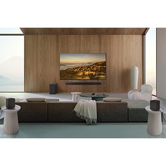 A living room with a TV, Samsung Soundbar Q990D, a subwoofer and two rear speakers.