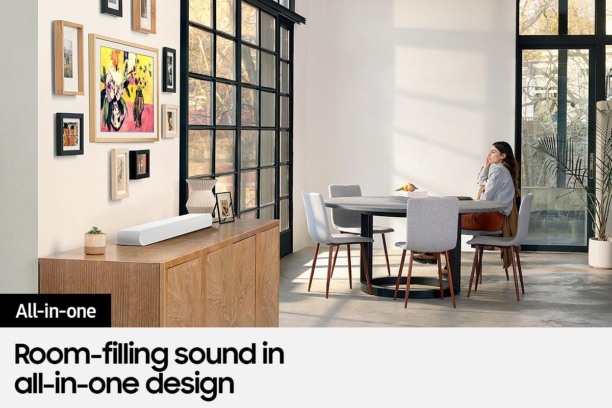 All-in-one design of S61B soundbar blends elegantly with living room interior as a woman sits at the table and looks out the window.